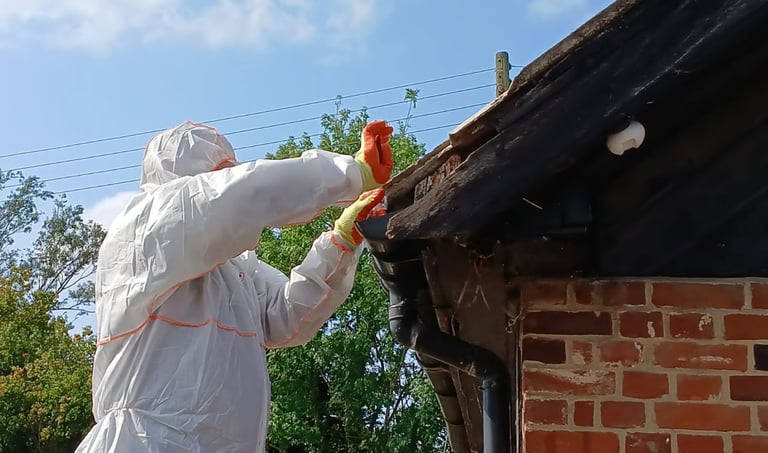 Licensed asbestos removal contractor removing garage roof materials in Essex using full protective equipment