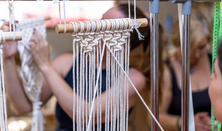 Nudos hechos con hilo blanco tejiendo sobre un palo de madera