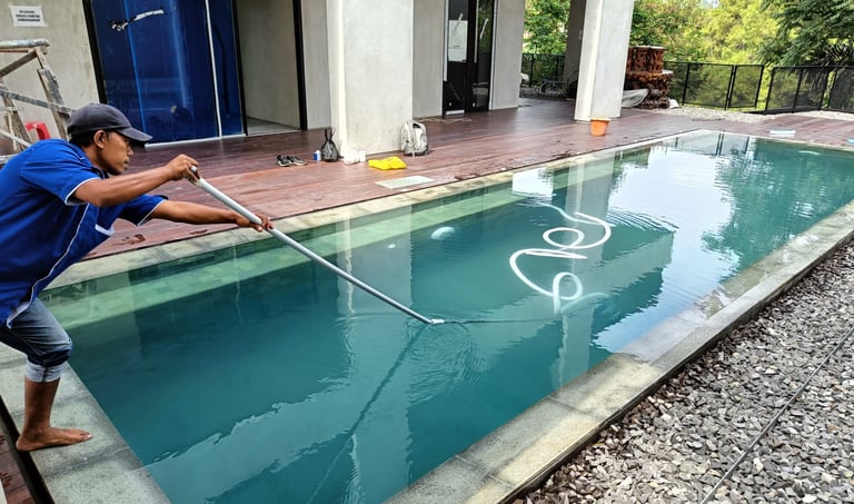 3.	Pekerja sedang membersihkan kolam renang dengan vakum.