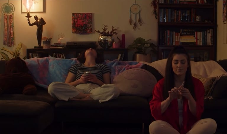 a woman sitting on a couch with a man and a woman