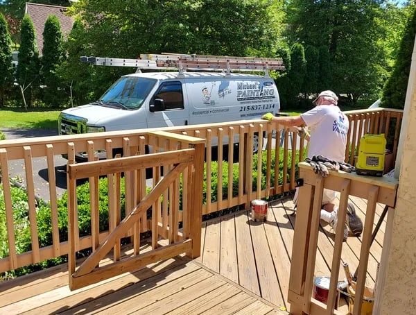 a man painting a deck with a van