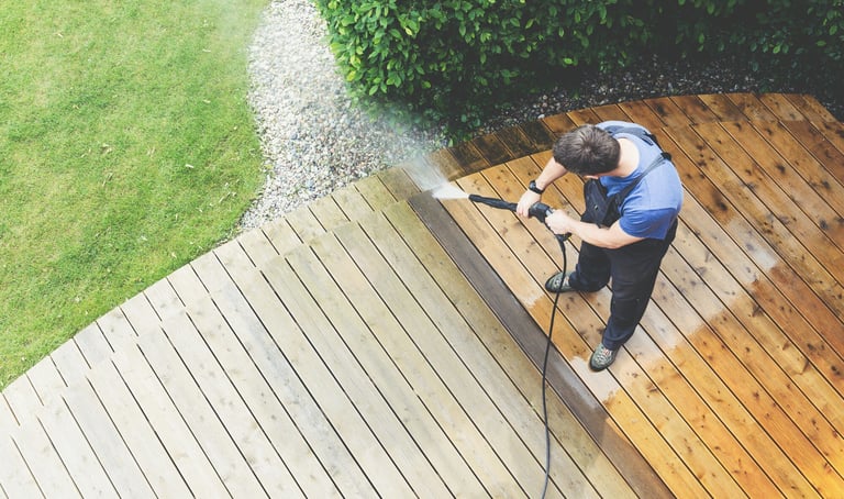 a man is using a pressurer to clean a deck deck