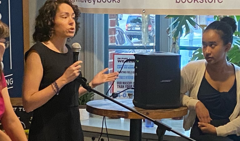 Becca Block holding a microphone speaking