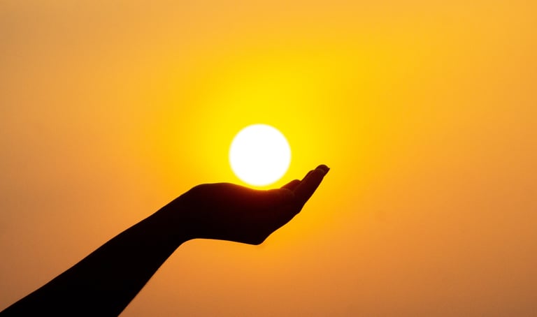 A cupped hand under a white sunlight with yellow glow