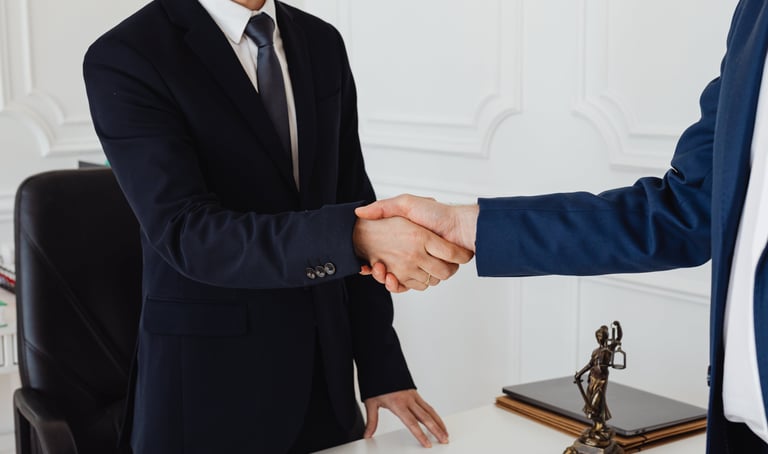 a man in a suit and tie is shaking hands