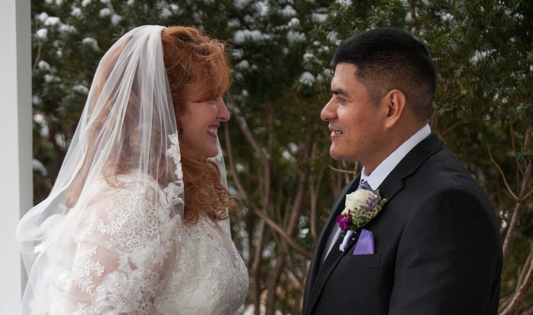a bride and groom standing in front of a white house