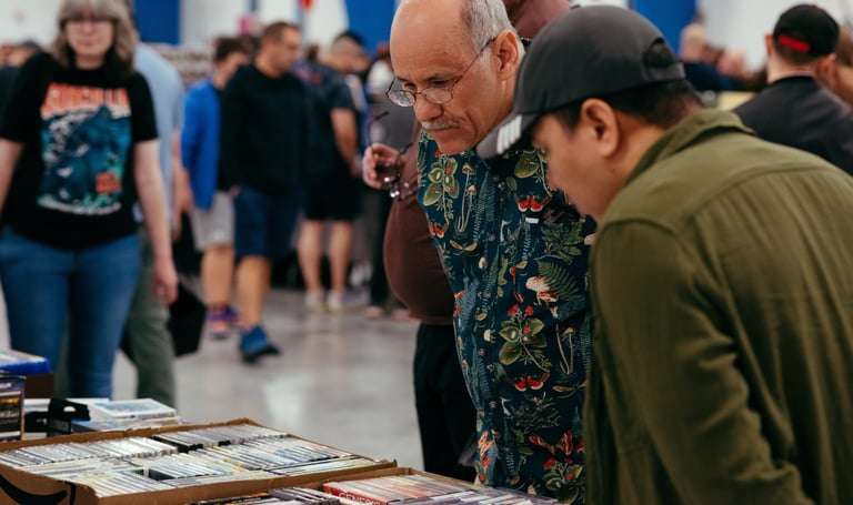 Two men look engaged and curious as they browse a selection of video games for sale.