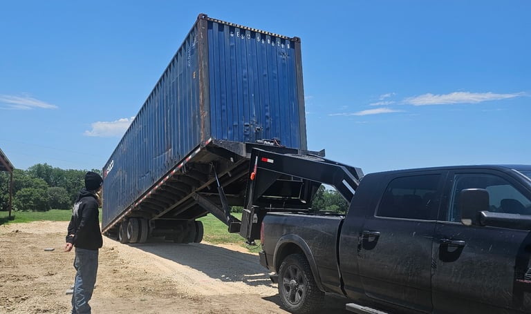 A 40ft blue cargo worthy container on a tilted trailer to be off loaded