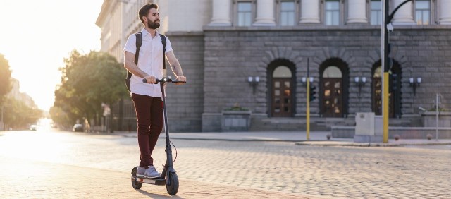 a man riding a scooter on a city street