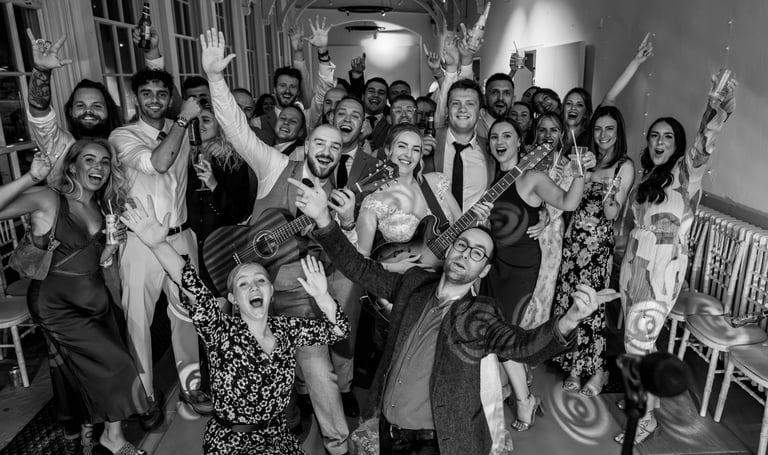 Bride and groom celebrating with wedding music duo family friends and guests