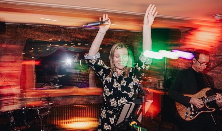 Female wedding party singer dancing with her arms up