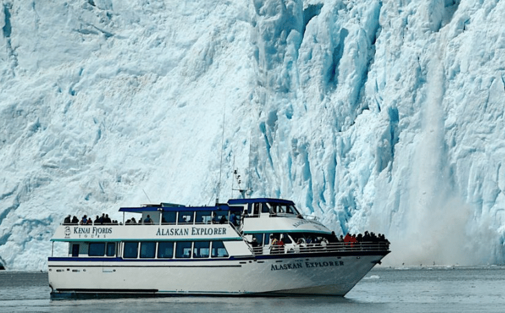 The Alaskan Explorer tour boat cruises past a massive calving glacier in Kenai Fjords National Park.