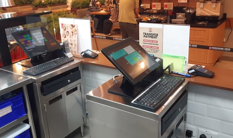 Two touchscreen POS stations in a high-volume cafeteria-style serving line