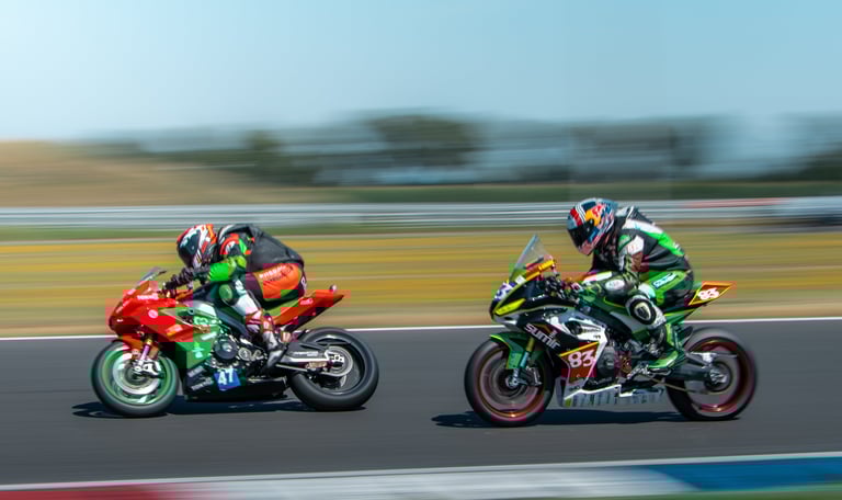 two people riding motorcycles on a track