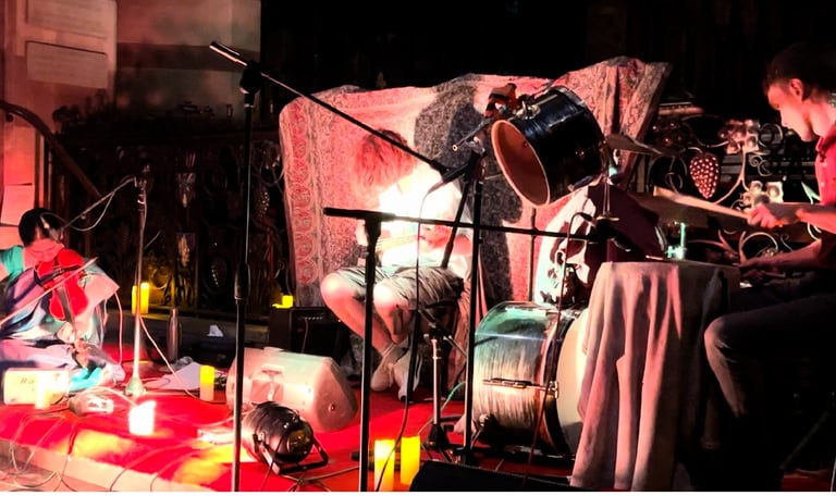 A picture of artists in violin, drums and guitar