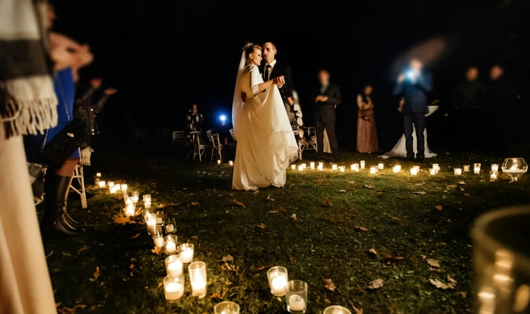 Brautpaar mit Gästen in einem Kreis aus Kerzen