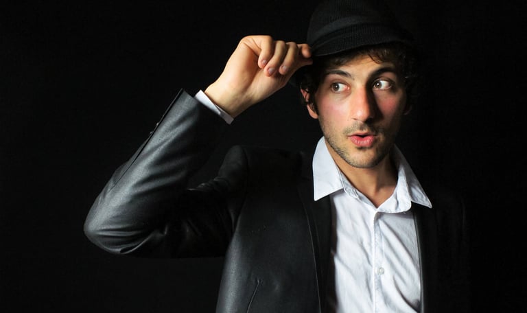 photo de portrait sur fond noir en studio, l'homme porte un chapeau