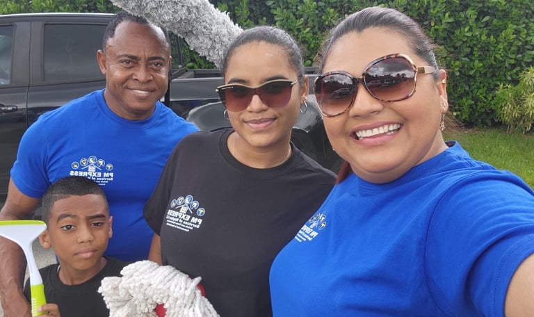 Professional residential cleaning team posing with window washing tools and cleaning supplies.