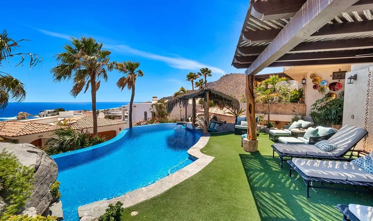 Luxury villa in Pedregal, Cabo San Lucas, with a large pool and palapa overlooking the ocean.