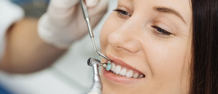 a woman is smiling for teeth cleaning