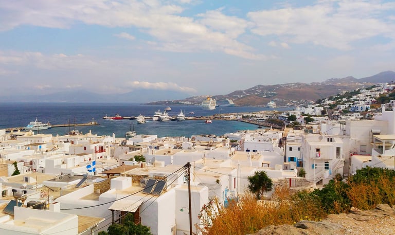 whitehouses looking at coast of Mykonos Greece with cruise ship in distance