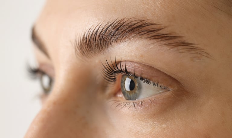 A female client in Oklahoma City showcasing the results of a lash lift and brow lamination, with her