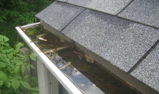 a gutter system not draining properly and leading to a buildup of debris and water
