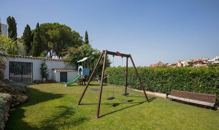 a swing set up in a garden with a swing set