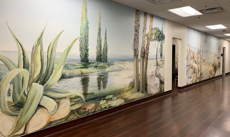 Two large panoramic murals in a clinic hallway depicting Southern Californian landscapes.