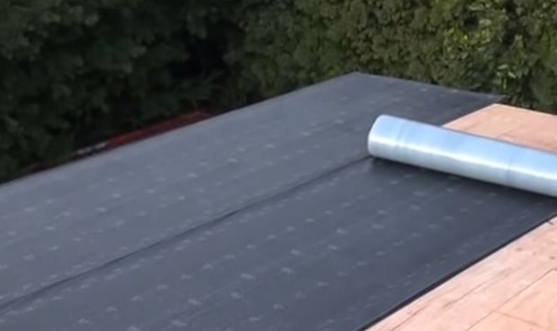 Waterproof roofing tar paper installed on Massachusetts-built shed for durable weather resistance.