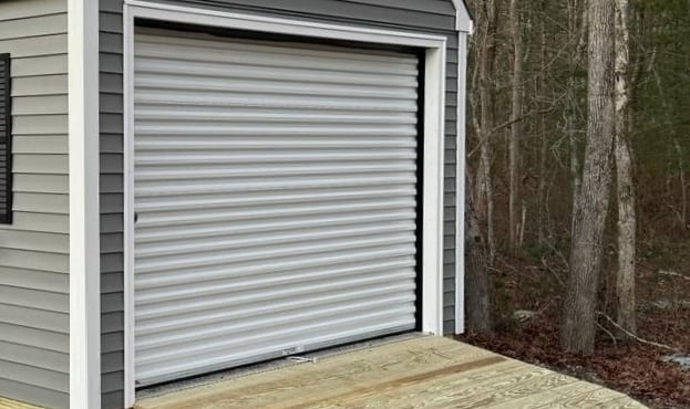 Custom shed with roll-up garage door built in Massachusetts for versatile storage solutions.