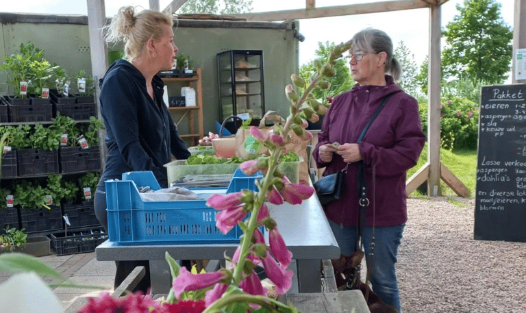 Twee vrouwen kletsen aan de toonbank van de streekwinkel