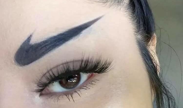 An example of unwanted permanent makeup: a woman with black Nike swoosh logos tattooed as her eyebro
