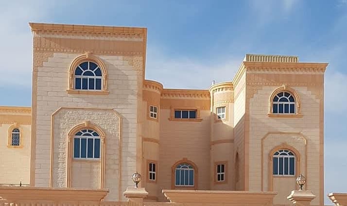 Grand villa with classical façade featuring arched windows, elegant columns, and aluminum framing.