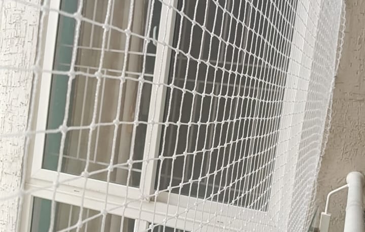 Close-up of a freshly installed child safety net on a balcony in Electronic City.