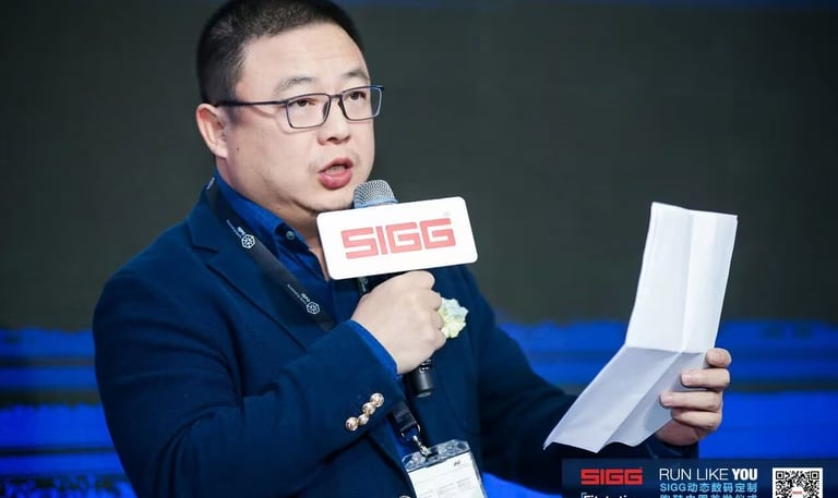 A man in a blue blazer speaking into a SIGG microphone while holding notes at an ISPO Beijing event.
