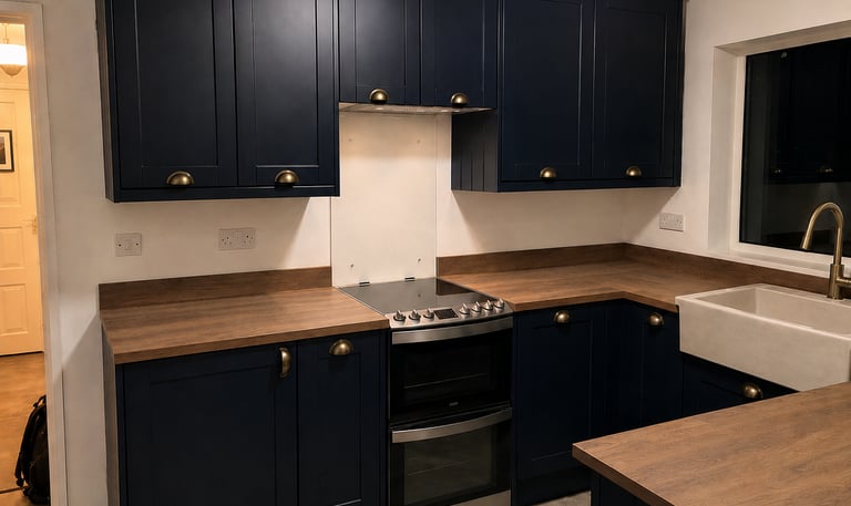 Navy shaker-style kitchen cabinets with brass handles, wood-effect countertops, fitted in Abingdon