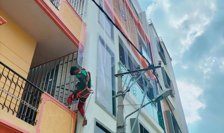 Close-up of a sturdy pigeon net tightly fitted on a balcony railing in a sunny Anna Nagar apartment.