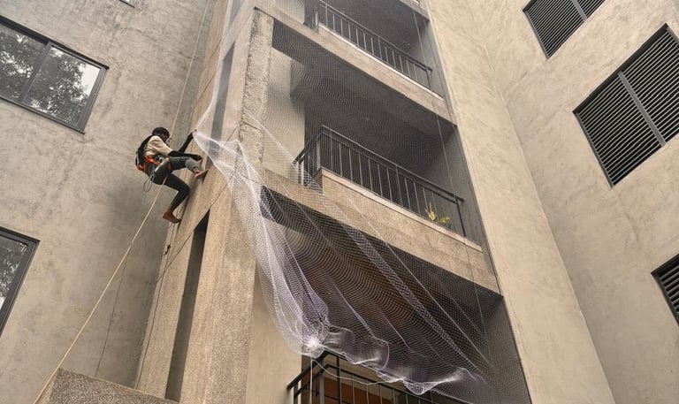 Close-up of a finely woven pigeon net tightly fitted on a Mumbai balcony railing.