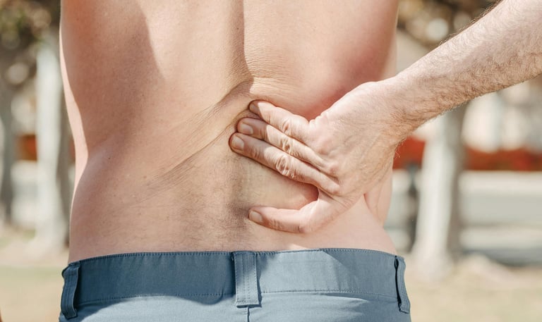 a man with a back pain holding his back