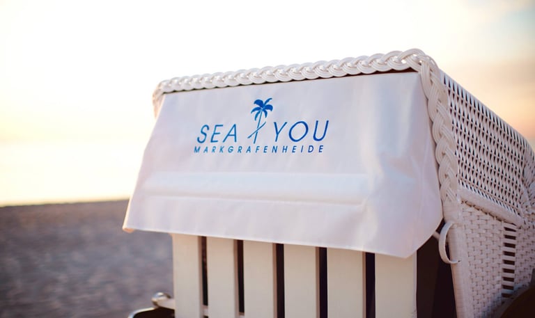 Strandkorb mit dem Logo SEA YOU bei Sonnenuntergang