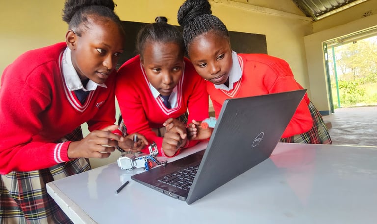 3 Kenyan girls in red sweaters building robots