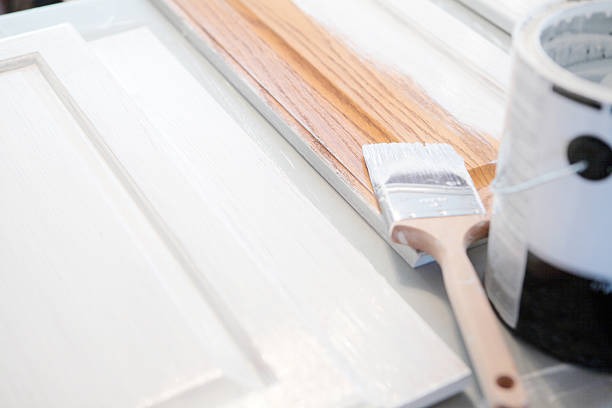 a paintbrush brush an can with cabinet doors