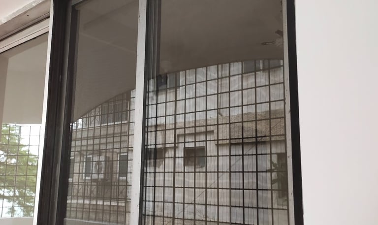 Wide shot of a spacious balcony in Whitefield fitted with a secure white velcro mosquito net.