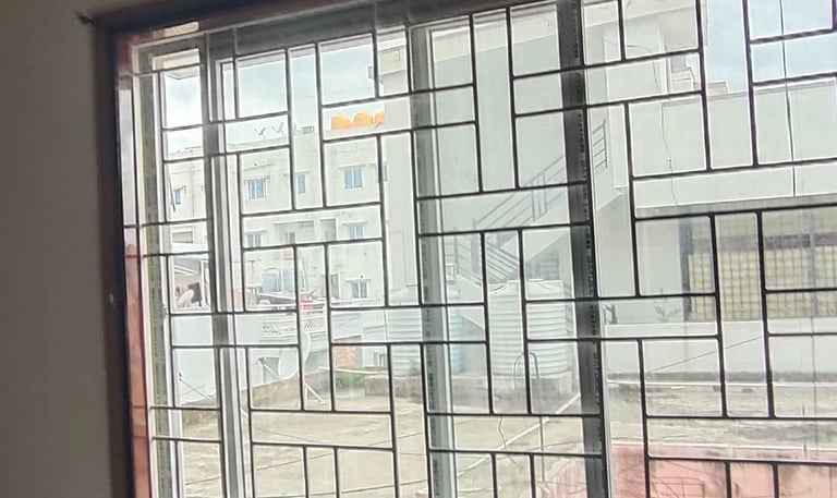 Close-up of a neatly installed velcro mosquito net on a balcony window in a Whitefield apartment.