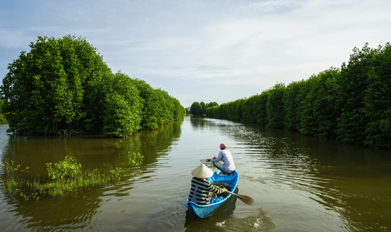 a man in a canoe on a river - SEMATA INDONESIA Program