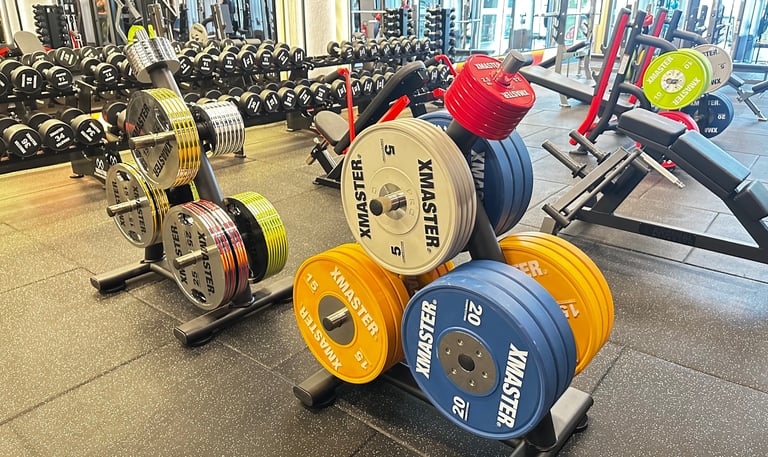 a gym room with a bunch of dumb dumbs and dumb dumbs