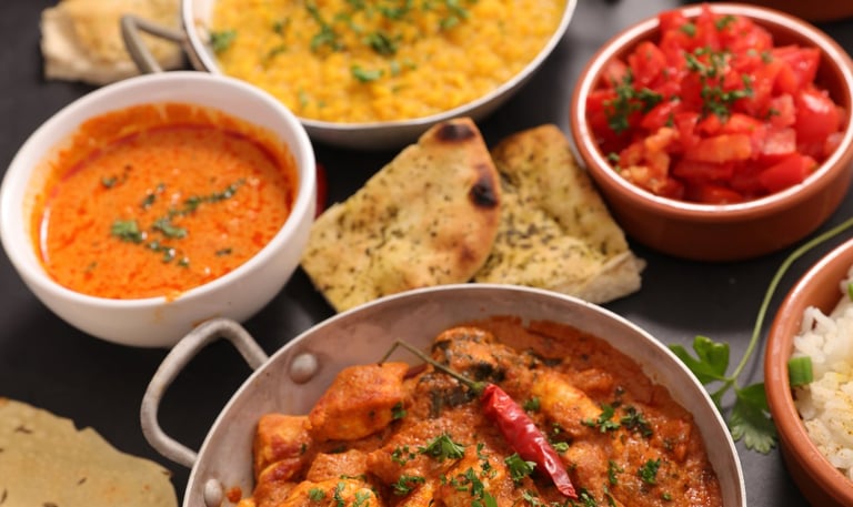 Indian vegetarian meal with paneer curry, naan bread, rice, dal, and traditional side dishes