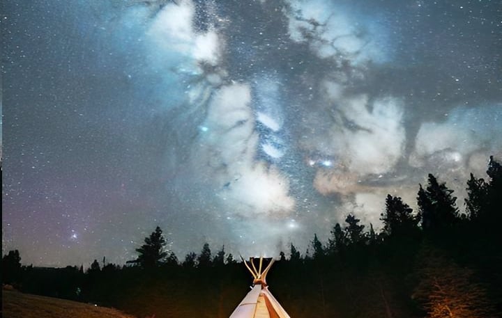 Teepee in a mountain meadow with milky way