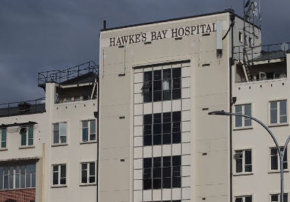 The exterior signage and white facade of Hawke's Bay Hospital building under a cloudy sky.
